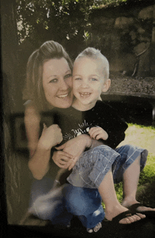 a woman is holding a young boy who is wearing a shirt that says ' jungle '