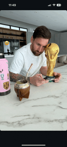 a man sits at a table with a trophy and a water bottle with a sticker on it