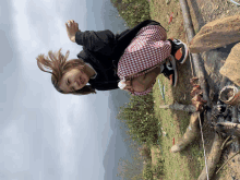 a girl in a plaid skirt is kneeling down in the dirt