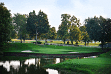 a golf course with a white fence and trees