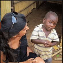 a woman is sitting next to a young boy who is looking at her