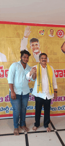 a man in a yellow scarf stands next to another man in front of a sign that says ' a ' on it