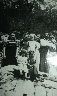 a black and white photo of a family posing for the camera