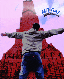 a man with his arms outstretched is standing in front of a red brick building with the word mr.rai on the bottom