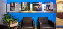 a row of black chairs in front of a blue wall with pictures on it including one that says brothers