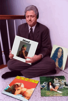 a man is sitting on the floor holding a blond record