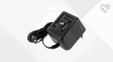 a black power supply with a cord attached to it on a white surface .