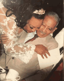 a woman in a wedding dress hugging an older man