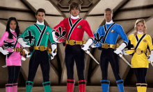 a group of power rangers standing next to each other with swords