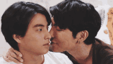 two men kissing each other on the forehead