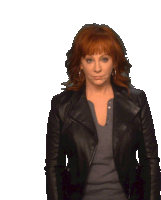 a woman with red hair is wearing a black jacket