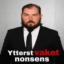 a man in a suit and tie stands in front of a sign that says " ytterst taket nonsens "