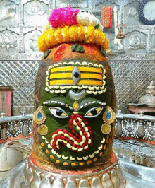 a statue of a deity in a temple with flowers on top of it