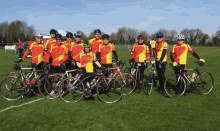 a group of cyclists are posing for a photo and one of their shirts says ' a ' on it