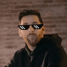 a man wearing a black hoodie and pixelated sunglasses looks at the camera