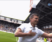 a man in a white shirt is running on a soccer field in front of a sign that says ' toyota ' on it