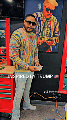 a man is standing in front of a painting of donald trump