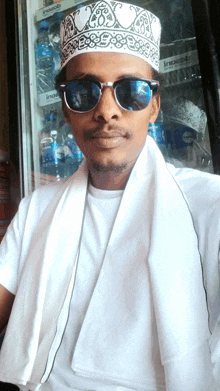 a man wearing sunglasses and a white hat is standing in front of a fridge that has pepsi bottles on it