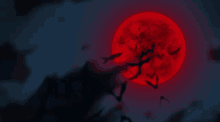 a full red moon is behind a tree with bats flying around it