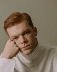 a man with red hair wearing a white turtleneck