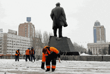 a statue of a man stands in front of a building that has a sign on it that says " russia "