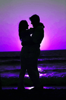 a silhouette of a man and woman hugging with a purple sky behind them