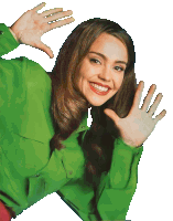 a woman in a green shirt is smiling with her hands up