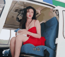 a woman in a red dress sits in a helicopter