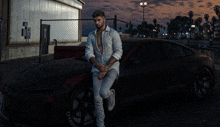 a man leans against a car with a tire that says pirelli