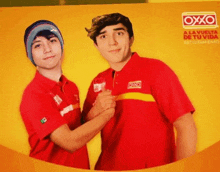 two young men are posing for a photo in front of an oxxo ad