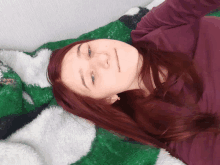 a woman laying on a green and white blanket