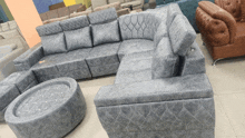 a large grey sectional couch with a round coffee table