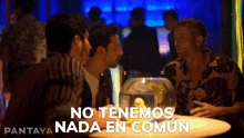 a group of men sitting around a table with the words no tenemos nada en comun on the bottom right