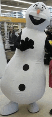 a snowman mascot stands in front of a yellow sign that says sandwiches