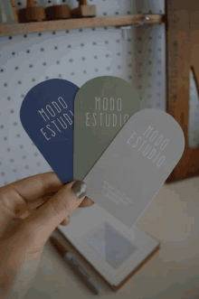 a person is holding three pieces of paper that say modo estudio