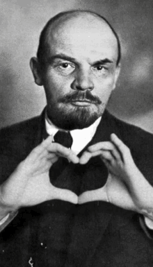 a man with a beard makes a heart shape with his hands