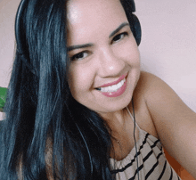 a smiling woman wearing headphones and a striped top