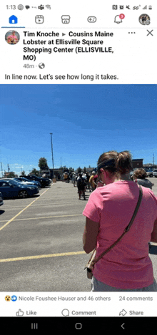 a woman in a pink shirt is standing in a parking lot in front of a shopping center