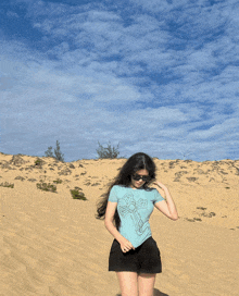 a woman in a blue t-shirt with a cross on it