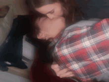 a woman in a plaid shirt kissing another woman