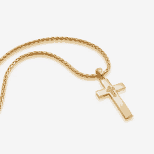 a gold necklace with a cross pendant on a chain