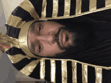 a man with a beard wears a black and gold costume