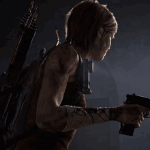 a woman is holding a gun in a dark room in the last of us part ii .