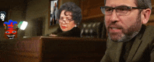 a man with glasses is sitting in front of a woman with glasses