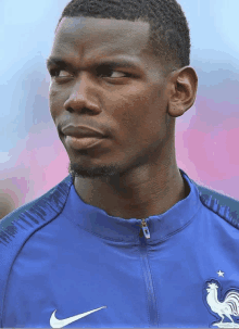 a close up of a man wearing a blue nike shirt