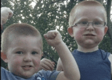 two young boys are flexing their muscles and smiling for the camera