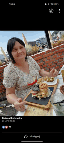 a woman is sitting at a table with a plate of food in front of her and the time is 13:05