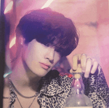 a man in a leopard print shirt holds a bottle in his hand