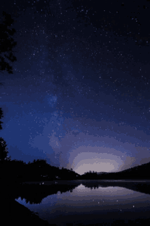 a starry night sky over a body of water