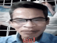 a man wearing glasses and a blue shirt is making a funny face in a video call .